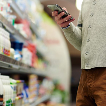 Guy shopper on phone in grocery